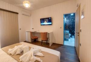 a bedroom with a bed and a table and a television at POLYMNIA III LUXURY APARTMENT ARGOSTOLI in Argostoli