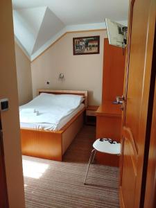 Dormitorio pequeño con cama y mesa en Motel Royal, en Tuzla