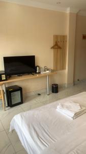 Habitación de hotel con cama y TV de pantalla plana. en 西港宾馆 en Sihanoukville