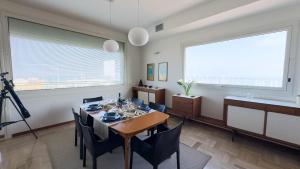 uma sala de jantar com mesa e cadeiras em Luxury Majestic Penthouse Apartment em Chioggia