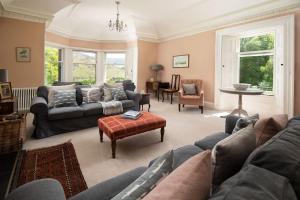 a living room with couches and a table at Mossfennan House & Annexe in Drummelzier