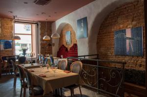 a restaurant with tables and chairs and a brick wall at Boutique Hotel Justus in Riga
