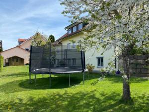 una casa con un aro de baloncesto en el patio en Ferienwohnung Meßmer, en Heiligenberg