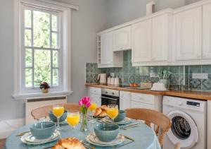 a kitchen with a table with food and orange juice at Waterhouse - Crimplesham Hall in Stradsett