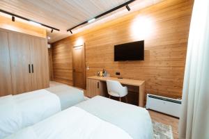 a hotel room with two beds and a television at Le Chalet by Amirsoy in Chimgan