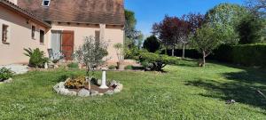 uma casa com um jardim com um canteiro de flores no quintal em Chambres d'hôtes Chez Dumitra em Calès