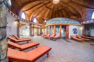 a group of chairs in a room with a large building at Hotel Piroska in Bük