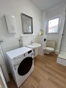 y baño con lavabo y lavadora. en Othman Appartements Falkenstraße 26 en Hannover