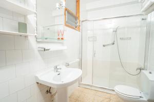 y baño blanco con lavabo y ducha. en Apartamentos Ancoradoiro, en Lariño