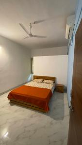 Un dormitorio con una cama y un ventilador de techo. en Sonchafa Stays, en Nagaon