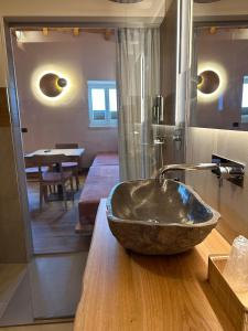 een badkamer met een stenen wastafel op een houten aanrecht bij Studios Al Castello dei Limoni in Limone sul Garda