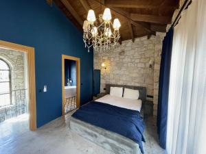 a bedroom with a bed with blue walls and a chandelier at Rhea Alaçatı Boutique Hotel in Alacati