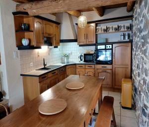 a kitchen with wooden cabinets and a wooden table at Gite tout confort 10 pers à 8 km du Lioran in Saint-Jacques-des-Blats
