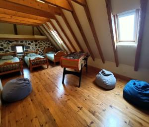 an attic room with beds and a table and a window at Gite tout confort 10 pers à 8 km du Lioran in Saint-Jacques-des-Blats