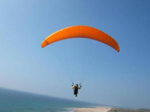 a person riding a parachute over the ocean at Hôtel Mont Thabor Serre Chevalier in La Salle Les Alpes