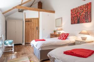 a bedroom with two beds and a table with a chair at The Granary in Yeovil
