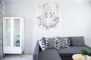 sala de estar con sofá y un dibujo en la pared en Bright apartment by the park & the river, en Wroclaw