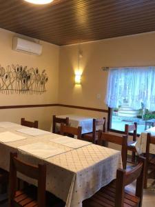 Hotel Bom Amigo في إنهامبان: غرفة طعام بها طاولات وكراسي ونافذة