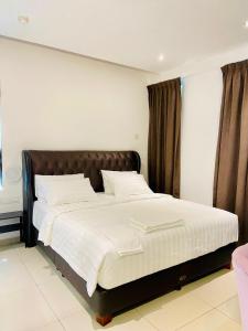 a bedroom with a large bed with white sheets at BIG TREE HOTEL in Temerloh