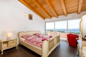 Un dormitorio con una cama y una ventana grande. en VB Jelčić Krk, en Krk