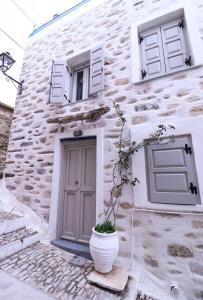 a building with a door and a plant in front of it at Rustic house in Ano Syros in Ano Syros