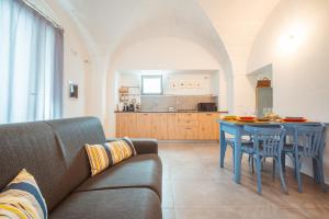 ポリニャーノ・ア・マーレにあるPoseidonia-Housea Travelのリビングルーム(ソファ、テーブル付)、キッチンが備わります。
