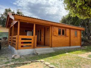 a small wooden cabin with a porch at Chalet 4 personnes à 5 mn des plages in Calcatoggio