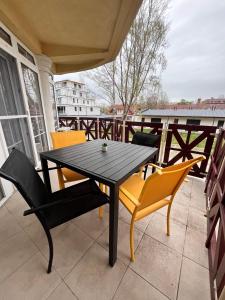 una mesa negra y sillas en el balcón en Károly Apartman, en Balatonlelle