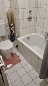 a bathroom with a toilet and a tub and a sink at Crazy Home in Hückelhoven