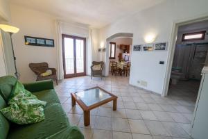 Una sala de estar con un sofá verde y una mesa. en La Gabbiana, en Portoferraio