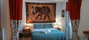 a bedroom with a bed with a picture of an elephant at Le Castellou in Conques