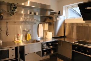 a stainless steel kitchen with a sink and a microwave at Milling Hotel Mini 11 in Odense