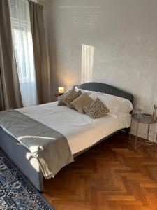 een bed in een slaapkamer met een houten vloer bij Garden View boutique apartments in Gorizia