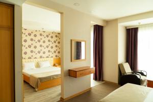 una camera d'albergo con letto e specchio di AEF Hotel a Baku