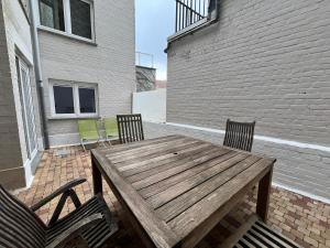 einen Holztisch und zwei Stühle auf einer Terrasse in der Unterkunft 'Broker' - Amazing 2 bedroom apartment near the beach in Ostende