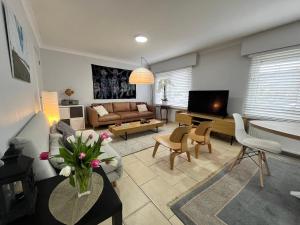 ein Wohnzimmer mit einem Sofa und einem TV in der Unterkunft 'Broker' - Amazing 2 bedroom apartment near the beach in Ostende