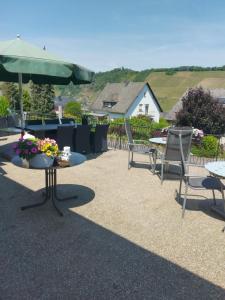 a group of tables and chairs with flowers on a patio at Ferienwohnung Rockenbach in Pünderich