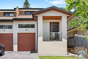 a house with two garage doors in front of it at Aircabin - Eastwood - Luxury - 4 Bedrooms House in Eastwood