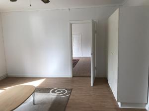 a white room with a surfboard on a wooden floor at Lägenhet/Apartment Krylbo, Avesta Sweden in Avesta