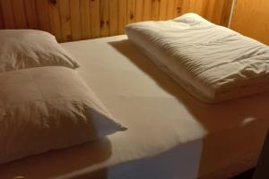 een bed met witte lakens en kussens erop bij Chalet le Brespail in Boutx