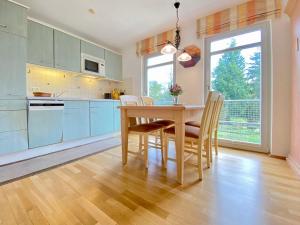 eine Küche mit einem Tisch und Stühlen sowie einem Fenster in der Unterkunft Residenz Bleichröder - Ferienwohnung 12 in Heringsdorf