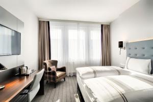 una camera d'albergo con letto e sedia di Premier Inn München City Ost a Monaco Altre 37 foto