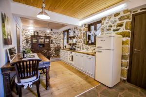 a kitchen with a white refrigerator and a table and chairs at Alexander Aqua Oasis - Poolside Garden Getaway in Evkarpía