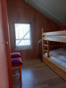 1 Schlafzimmer mit 2 Etagenbetten und einem Fenster in der Unterkunft Chalet le Brespail in Boutx