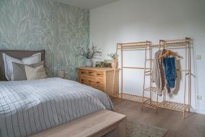 ein Schlafzimmer mit einem Bett, einer Kommode und einem Regal in der Unterkunft Stilvolle Seewohnung in Utting in Utting am Ammersee