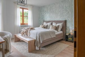 a bedroom with a bed and a window and a table at Stilvolle Seewohnung in Utting in Utting am Ammersee