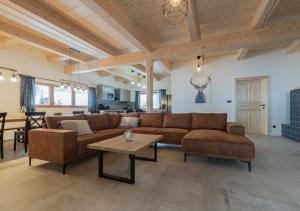 大卡尔洛维采Chata Pluskacka的客厅里有一张棕色沙发和一张桌子