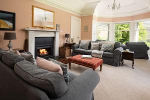 a living room with couches and a fire place at Mossfennan House in Drummelzier