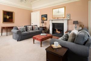 a living room with two couches and a fireplace at Mossfennan House in Drummelzier