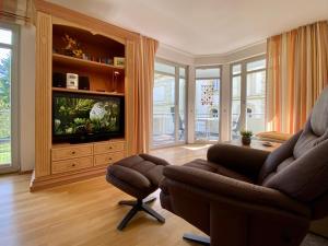 ein Wohnzimmer mit einem Sofa und einem TV in der Unterkunft Residenz Bleichröder - Ferienwohnung 12 in Heringsdorf
